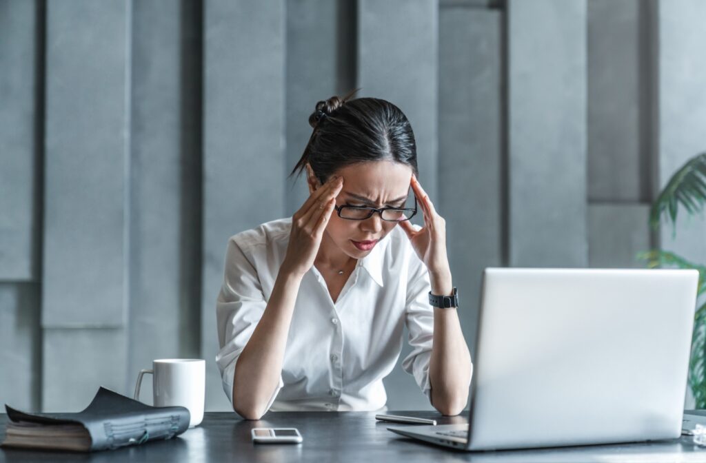 An office worker suffering from a headache rubs their temples.