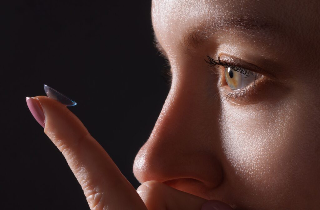 A contact lens wearer examining an expired lens close up